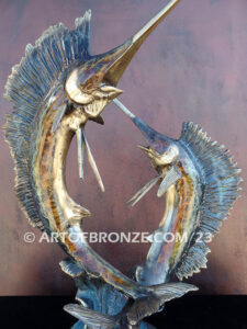 Parlay bronze sculpture of two sailfish leaping upward above ocean waves on marble base