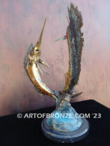 Parlay bronze sculpture of two sailfish leaping upward above ocean waves on marble base