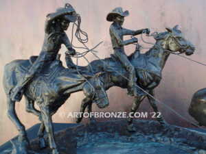 Round Up rodeo bronze sculpture of cowboys on horseback catching a steer