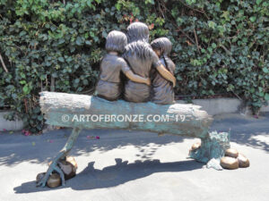 Special Touch bronze sculpture of three kids sitting on log with a injured baby bird in their hands