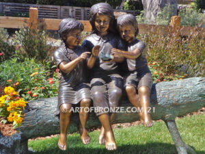 Special Touch bronze sculpture of three kids sitting on log with a injured baby bird in their hands