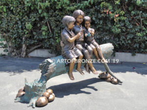 Special Touch bronze sculpture of three kids sitting on log with a injured baby bird in their hands