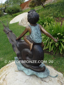 Snail Race outdoor bronze statue of young boy on snail