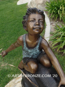 Snail Race outdoor bronze statue of young boy on snail