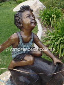 Snail Race outdoor bronze statue of young boy on snail