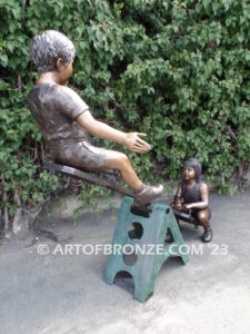 Teeter Totter bronze sculpture of children playing on teeter totter.