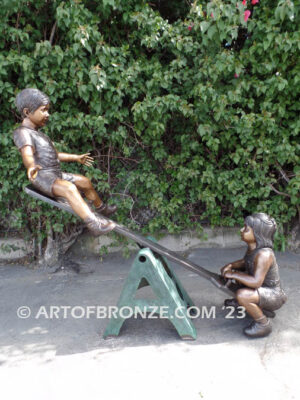 Teeter Totter bronze sculpture of children playing on teeter totter.