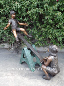 Teeter Totter bronze sculpture of children playing on teeter totter.