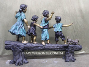 Log of Happiness bronze sculpture of four kids and dog playing on log