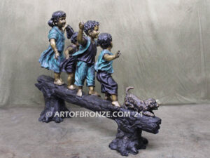 Log of Happiness bronze sculpture of four kids and dog playing on log